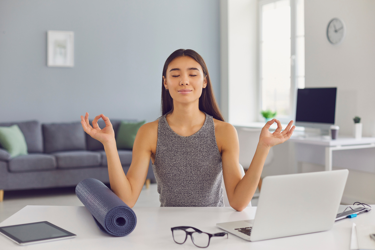 Relaxed Business Lady Sitting at Desk in Her Office Taking Break from Work and Practicing Meditation
